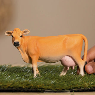 Model cow on a grassy surface