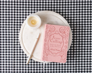 Jesus Calling pink leathersoft devotional by Sarah Young on marble tray with candle and pen