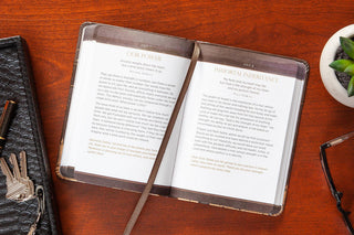 Open Jesus First for Men devotional showing July 1-2 pages with gold foil typography on imitation leather cover