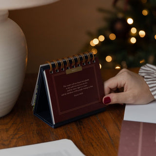 Burgundy spiral-bound Advent flipbook on wood desk showing Day 5 Genesis 49:10 verse