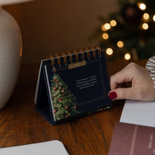 Navy advent flipbook Day 19 with Christmas tree illustration on wooden desk