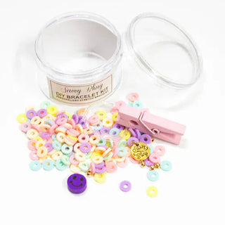 Pastel cereal ring bead bracelet kit with glossy plastic texture, purple smiley face bead, and pink wooden clothespin