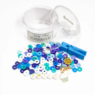 Savvy Bling DIY bracelet kit with navy blue and teal matte beads, gold foil letter charms spelling smile, and wooden clothespin