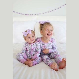 Matching lavender floral rompers for siblings infant and toddler overhead styling shot