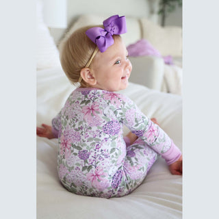 Lavender floral baby romper with pink bows on white bamboo viscose fabric, side view showing soft drape