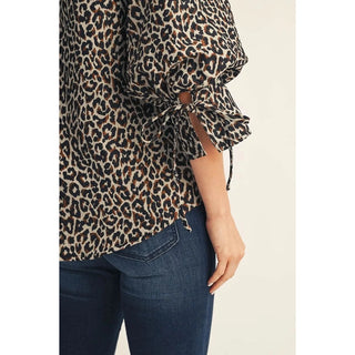 Leopard jacquard blouse sleeve detail with bow tie, paired with dark jeans