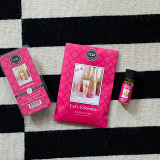 Bridgewater Let's Celebrate scented wax bar, sachet, and fragrance oil on striped rug