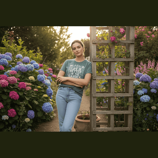 Woman wearing relaxed fit light green garden tee with botanical print standing in sunlit hydrangea garden