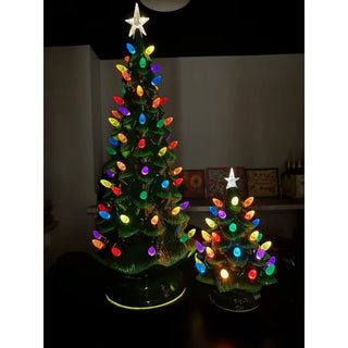 Two glowing green ceramic Christmas trees with multicolor bulb lights and star toppers