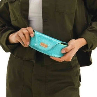 Person holding a turquoise wallet with a visible brand logo.