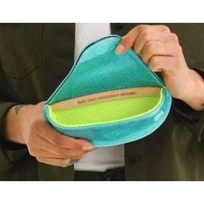 Person holding a teal and green pouch with text on it