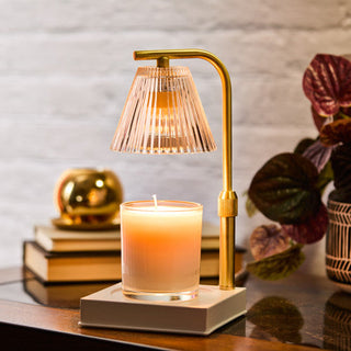 Luna Candle Warmer Lamp in gold with ribbed glass shade warming a pillar candle