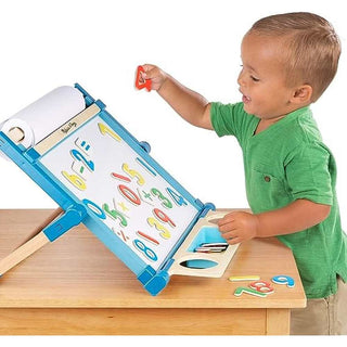 Toddler playing with Melissa & Doug magnetic wooden numbers on blue-framed dry-erase board