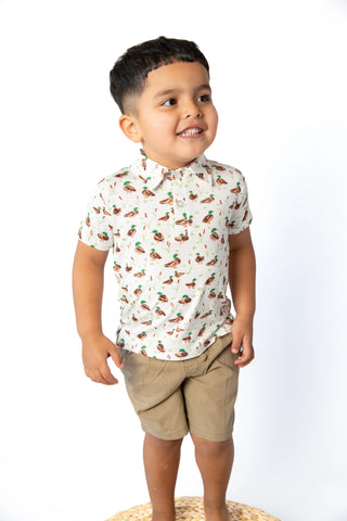 Toddler boy wearing white mallard duck print polo shirt with khaki shorts