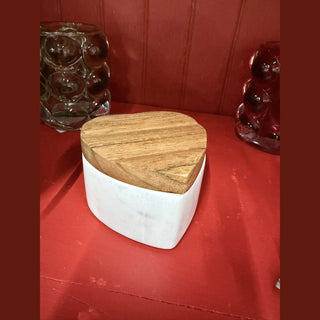 White marble heart trinket box with acacia wood lid on red surface