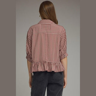 Back view of brick red gingham peplum top showing centered seam and ruffle hem