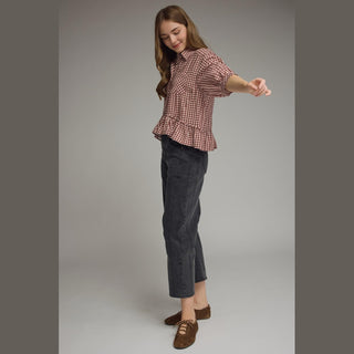 Side profile of flowy maroon gingham blouse highlighting relaxed peplum silhouette