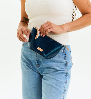 Model holding open a navy glitter Consuela Medium Tool Kit cosmetic pouch against white background