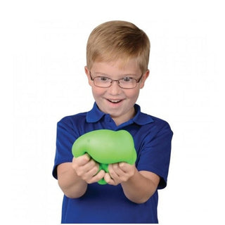 green squishy toy compressed in hands showing soft rubbery texture and deformation