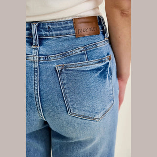 Close-up of Judy Blue leather brand patch and double stitched back pocket on medium wash denim
