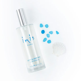 Clear spray bottle labeled 'inis home' with blue droplets 