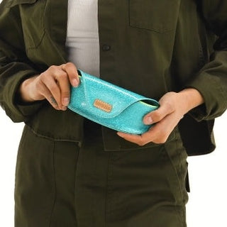 Person holding a turquoise wallet with a visible brand logo.