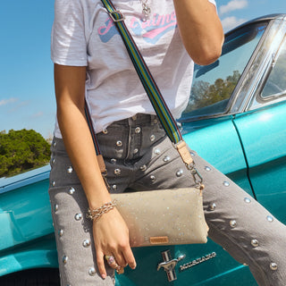 Person holding a beige handbag with a car 