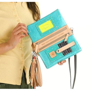 Turquoise handbag with keyboard design held by a person wearing a yellow shirt.
