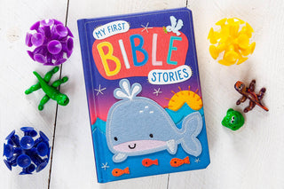 My First Bible Stories closed padded hardcover board book with gradient cover and smiling gray felt whale illustration