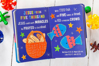 Jesus Feeds Five Thousand padded board book featuring embroidered felt fish and bread loaves on purple pages