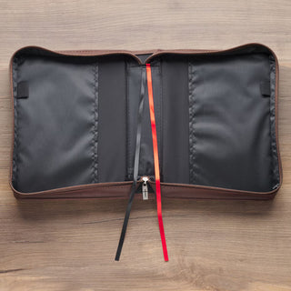 Open brown leather Bible cover with black interior pockets, red and black ribbon bookmarks