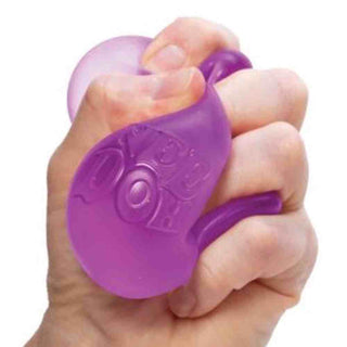 Child squeezing vibrant purple NeeDoh cube demonstrating flexible deformation and tactile play
