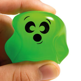 Hand holding a small green ghost-shaped squishy toy with a surprised face expression