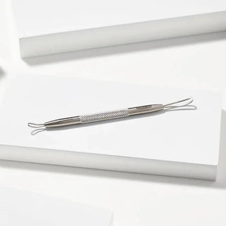 Polished silver Tweezerman skin care tool with opposing open loops for DIY facial