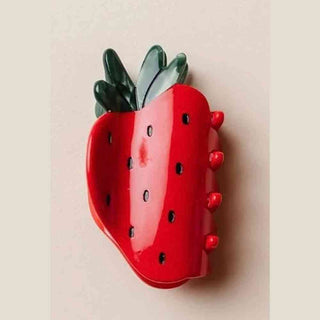 glossy red strawberry hair clip with green leaves and seed texture detail
