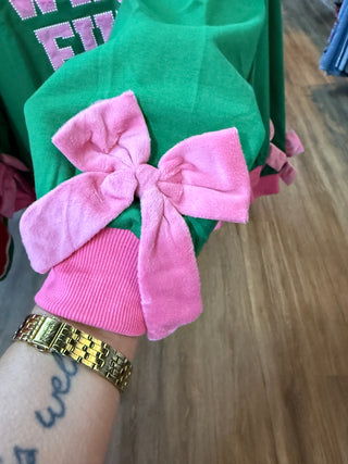 Green mock neck top with pink velvet bow detail on sleeve cuff
