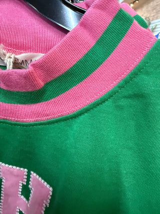 Green mock neck sweatshirt with pink striped collar and pink letter appliqué