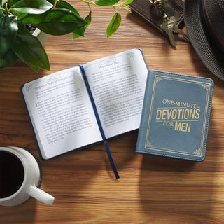 One-Minute Devotions for Men faux leather book shown closed and open on wooden table