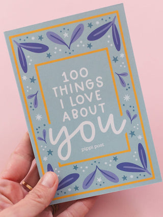Hand holding Pippi Post 100 Things I Love About You prompted journal with floral design