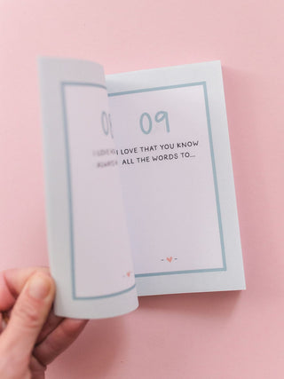 Hand holding open '100 Things I Love About You' prompted journal showing page 09