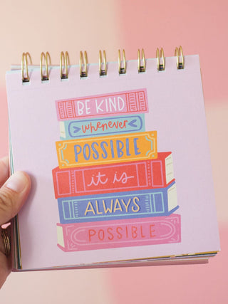 Spiral-bound desk flip calendar with colorful stacked books design reading Be Kind Whenever Possible It Is Always Possible