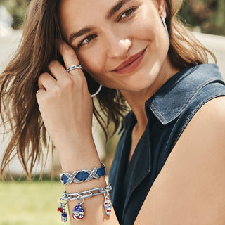 Woman wearing silver-tone Patriot egg charm with red white blue enamel stars on bracelet