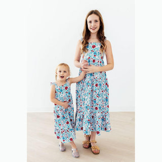 Two children wearing matching floral dresses