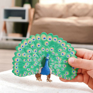 Schleich peacock figurine with fanned tail feathers held in hand, showing detailed paint.