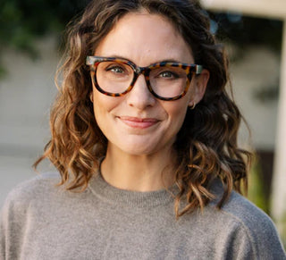 Woman wearing Peepers Buffy tortoiseshell reading glasses with green temple tips and amber swirls