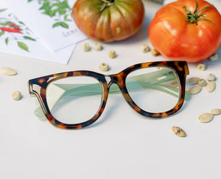 Peepers Buffy tortoise acetate reading glasses with green inner temple accents flat lay on white surface