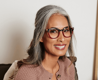 Woman wearing Peepers Cleo glasses in Brown Ombre Horn with tortoise detailing, smiling warmly
