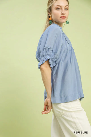 Woman wearing a light blue blouse with ruffled sleeves 