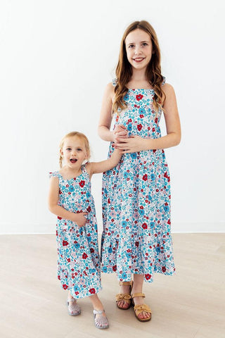 Two children wearing matching floral dresses