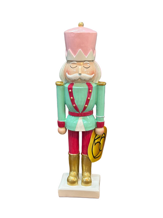 Enesco pink and mint green soldier nutcracker figurine with gold boots and red accents